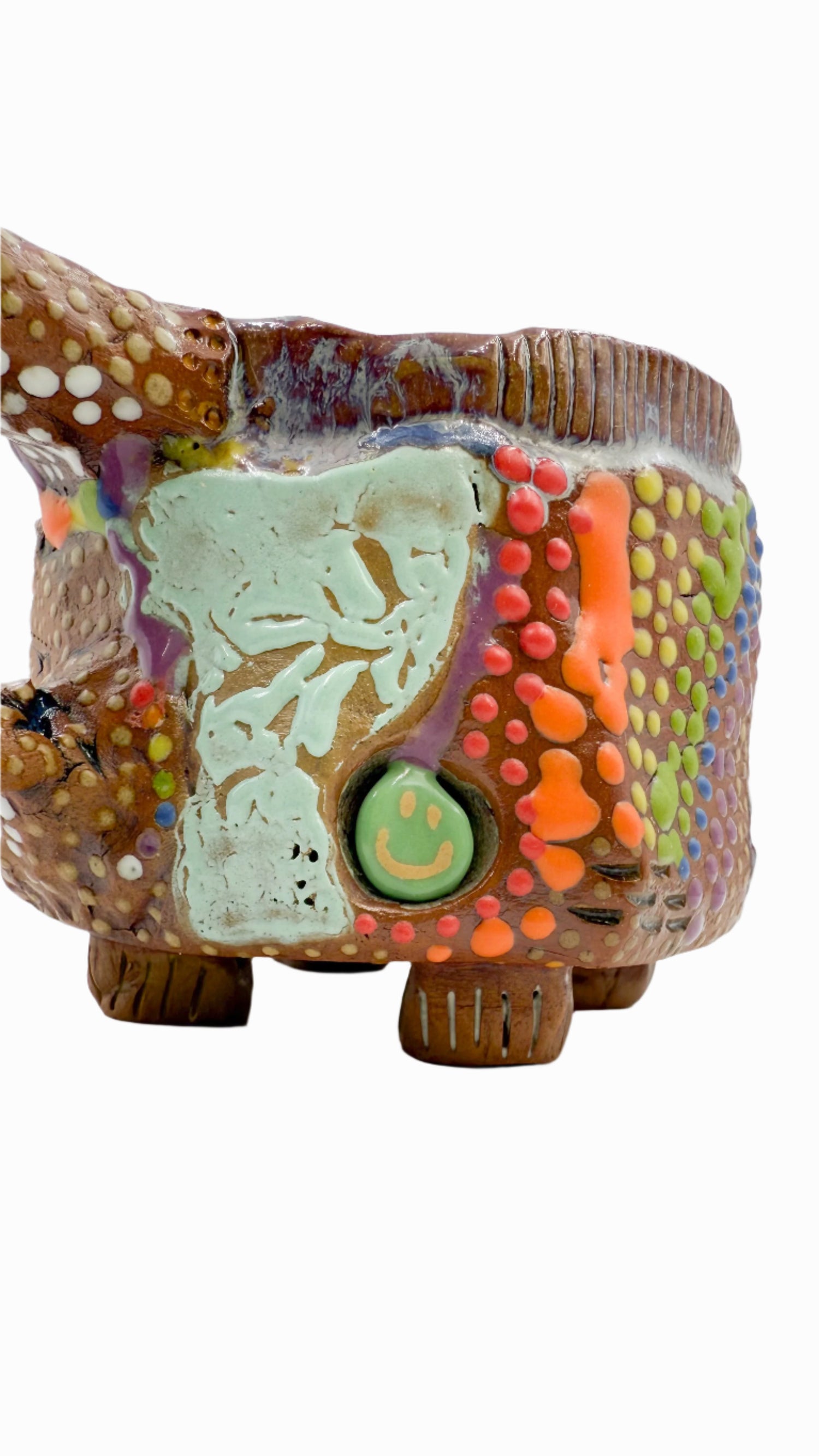 handmade mug glazed with rainbow dots and a turquoise smiley face