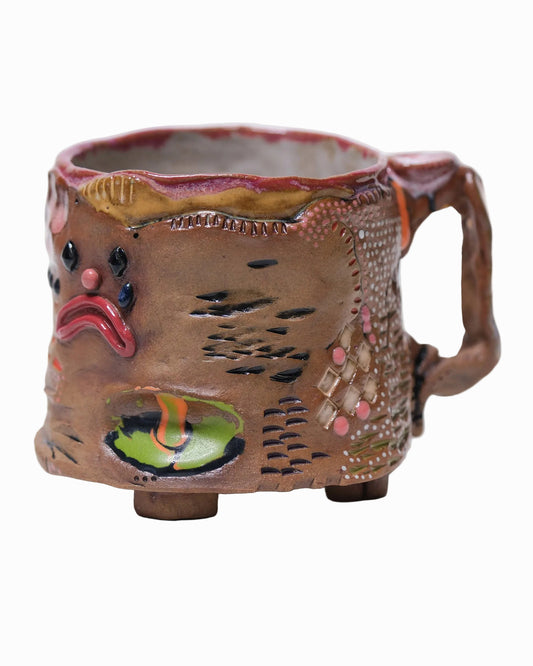 Pictured is a handmade ceramic mug that is full of gloops and globs allowing the mug holder to have a tactile experience while enjoying their preferred drink.
