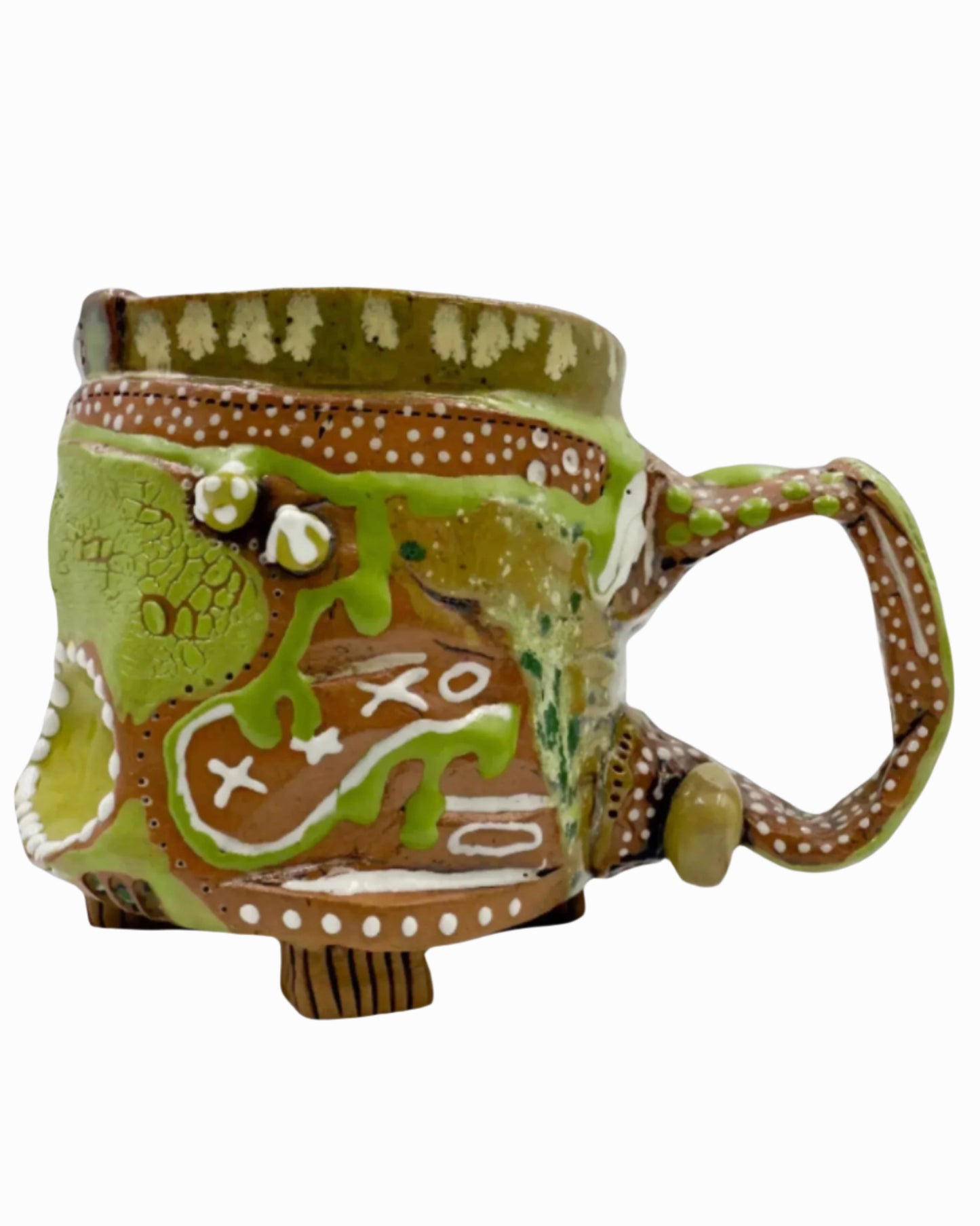 The image shows a hand built coffee mug primarily glazed in green and white. It is full of gloops and globs allowing the mug holder to have a tactile experience while enjoying their peferred drink.