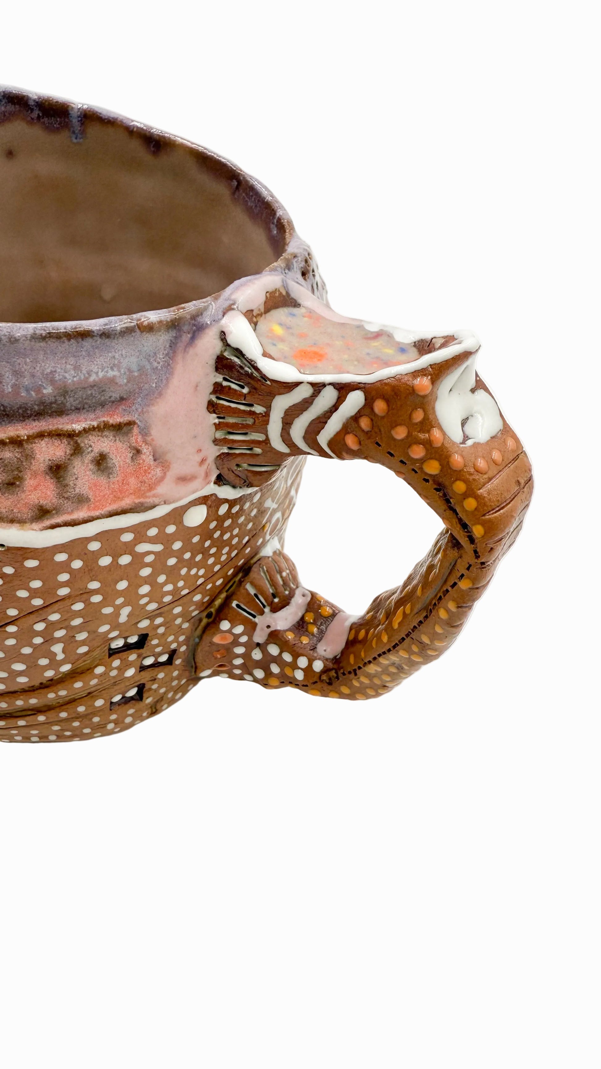 Pictured is a handmade ceramic mug that is full of gloops and globs allowing the mug holder to have a tactile experience while enjoying their preferred drink.
