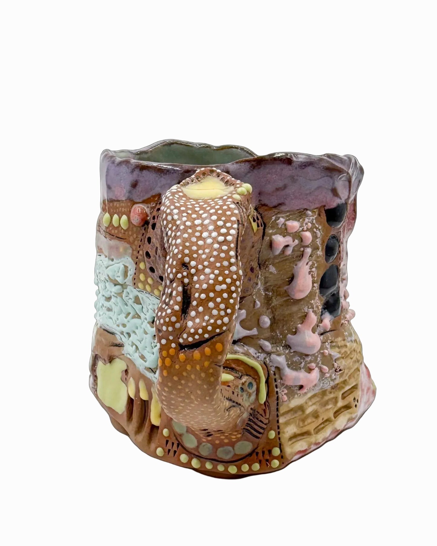 Pictured is a handmade ceramic mug that is full of gloops and globs allowing the mug holder to have a tactile experience while enjoying their preferred drink.
